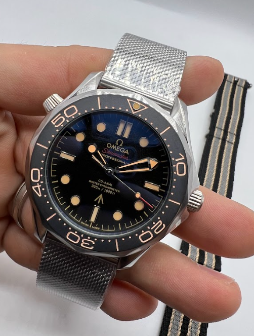 Relógio Omega com pulseira metálica e mostrador azul-escuro, detalhes dourados