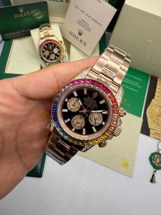 Relógio Daytona com pulseira metálica, mostrador escuro e bezel arco-íris cravejada