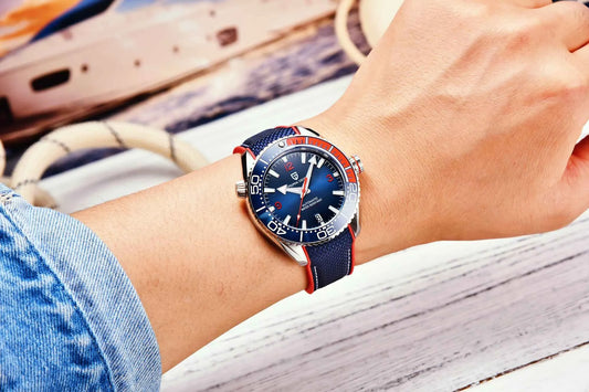 Relógio automático azul com pulseira de tecido azul e detalhes vermelhos no pulso