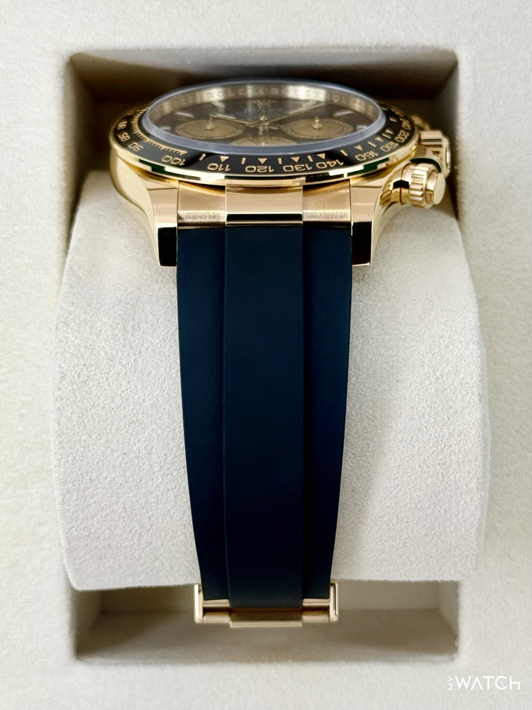Relógio Daytona com caixa dourada e pulseira de borracha azul, visto de cima.