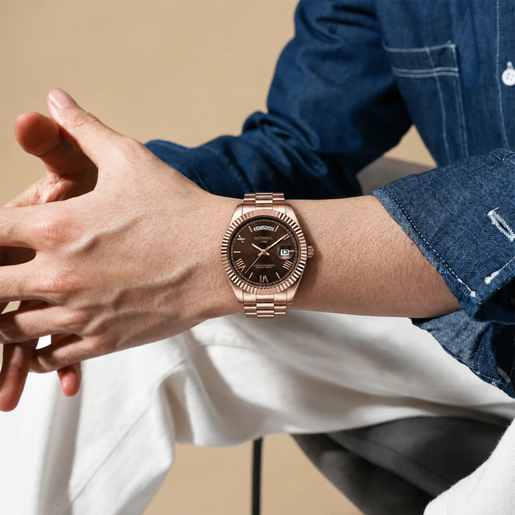 Relógio Movara® Soberano rosé no pulso, mostrador marrom e calendário em 13.