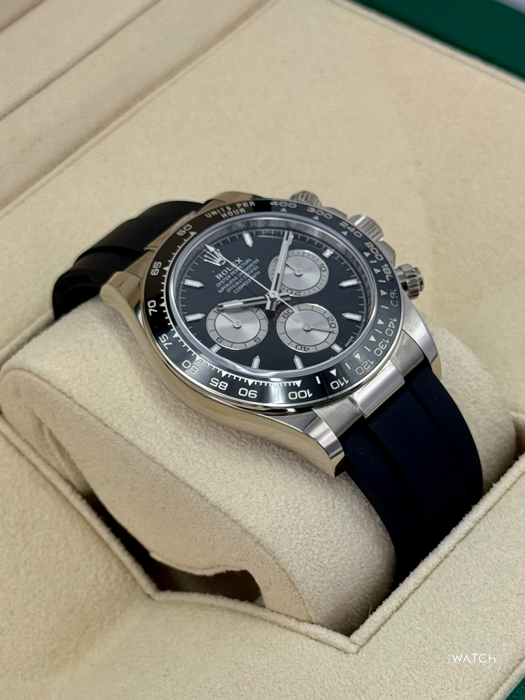 Relógio Daytona prateado com mostrador preto e cronógrafos, pulseira azul-marinho
