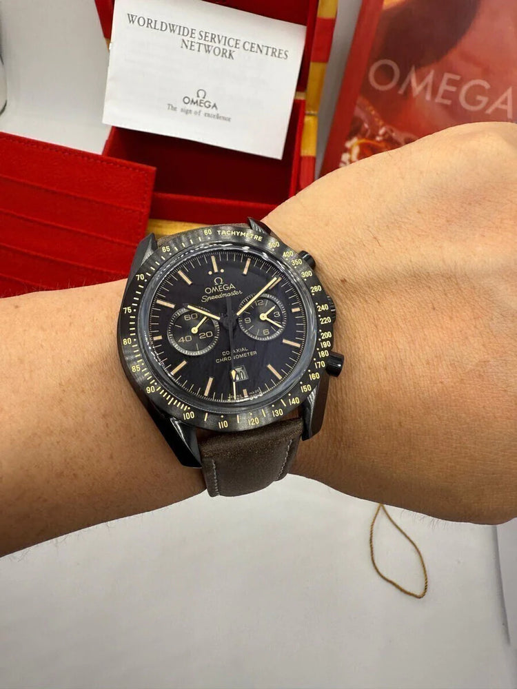 Relógio Omega Speedmaster no pulso, mostrador preto com bezel taquimétrico