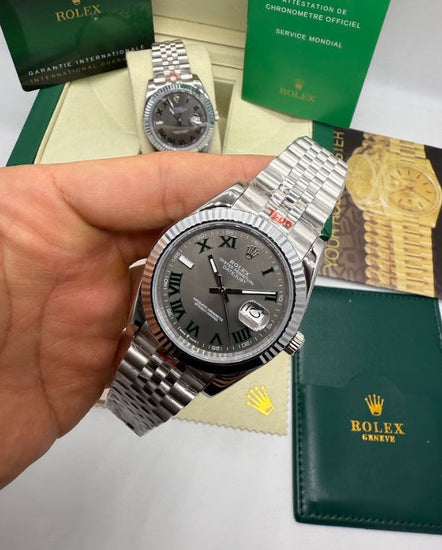 Relógio Rolex Datejust 41mm na mão, mostrador escuro com detalhes verdes e pulseira de aço