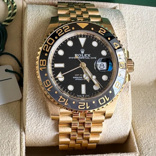 Relógio Rolex GMT Master II em ouro, mostrador preto com aro dourado e marcações azuis