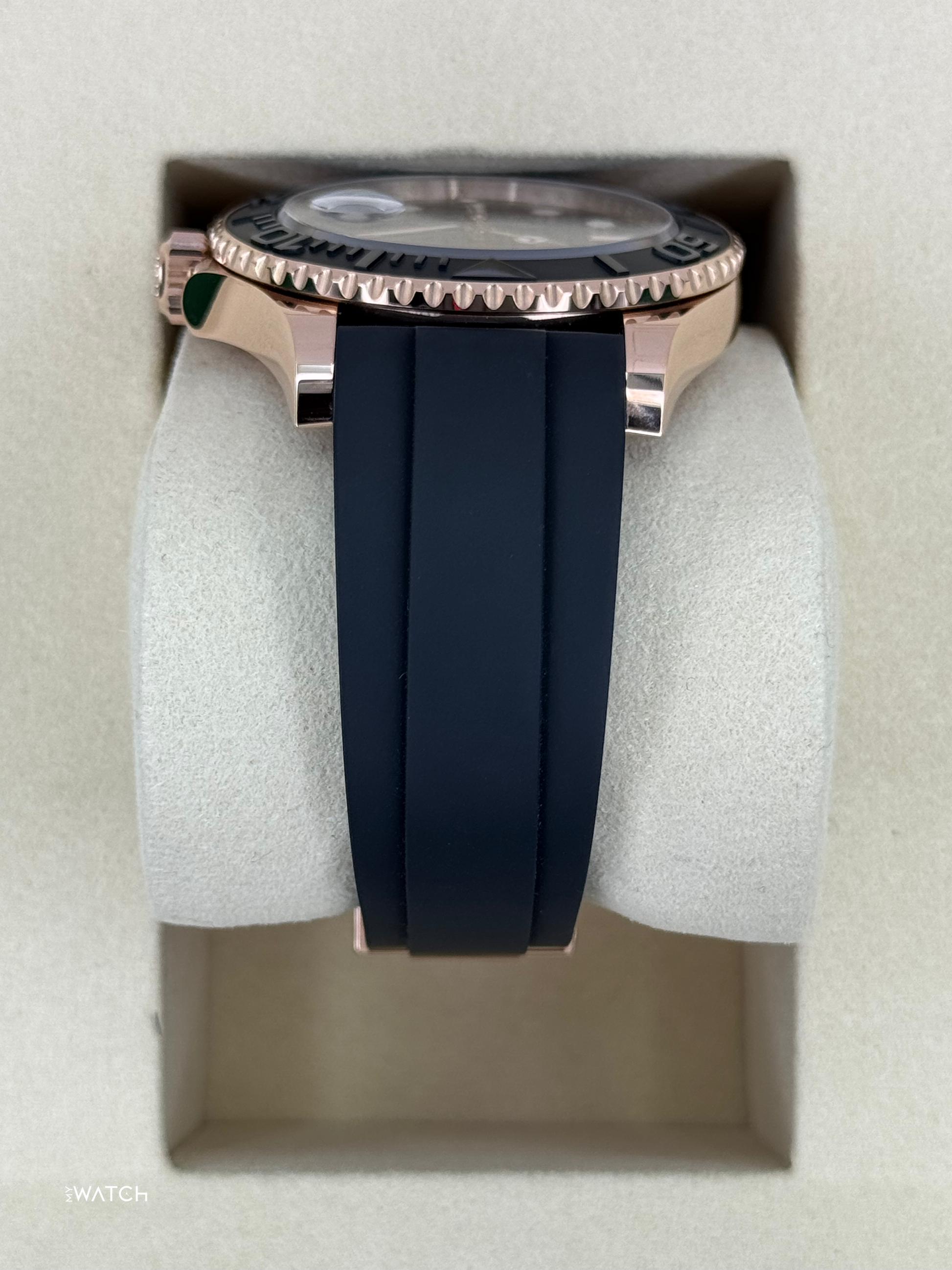 Relógio Rolex com caixa em ouro rosé, moldura preta com marcações e pulseira preta