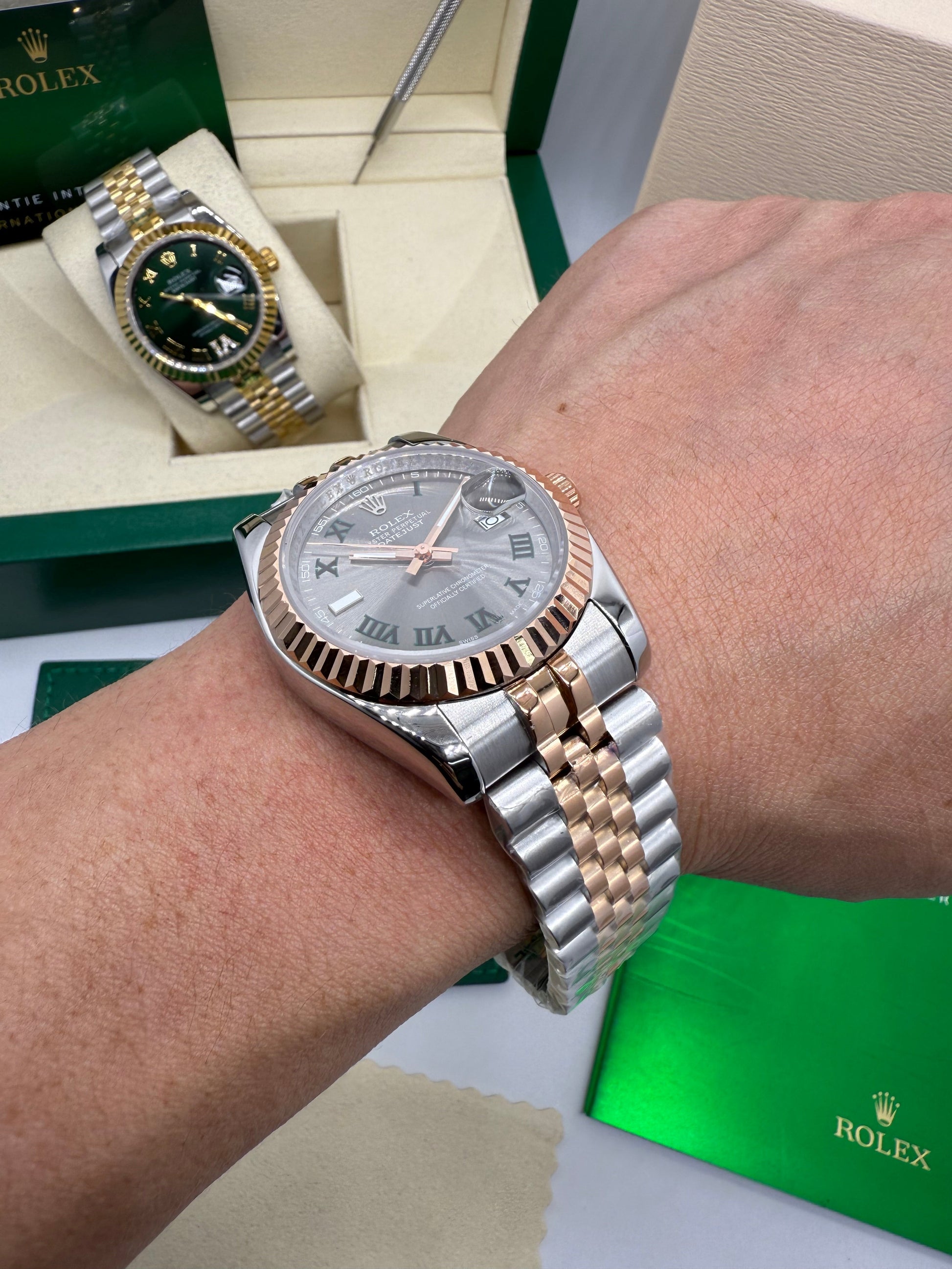 Relógio Rolex Datejust com pulseira bicolor aço e ouro, mostrador verde-escuro, na mão