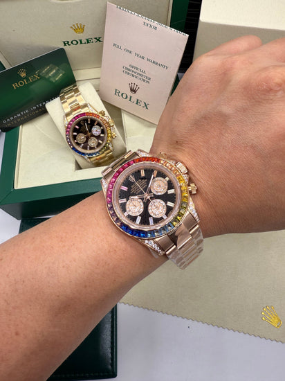 Relógio Daytona no pulso, pulseira metálica e bezel colorida com cronógrafo no mostrador
