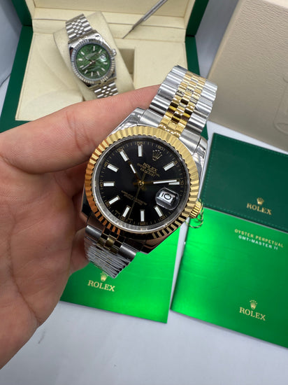 Relógio Rolex Datejust em aço e ouro, mostrador preto e pulseira Jubilee na mão