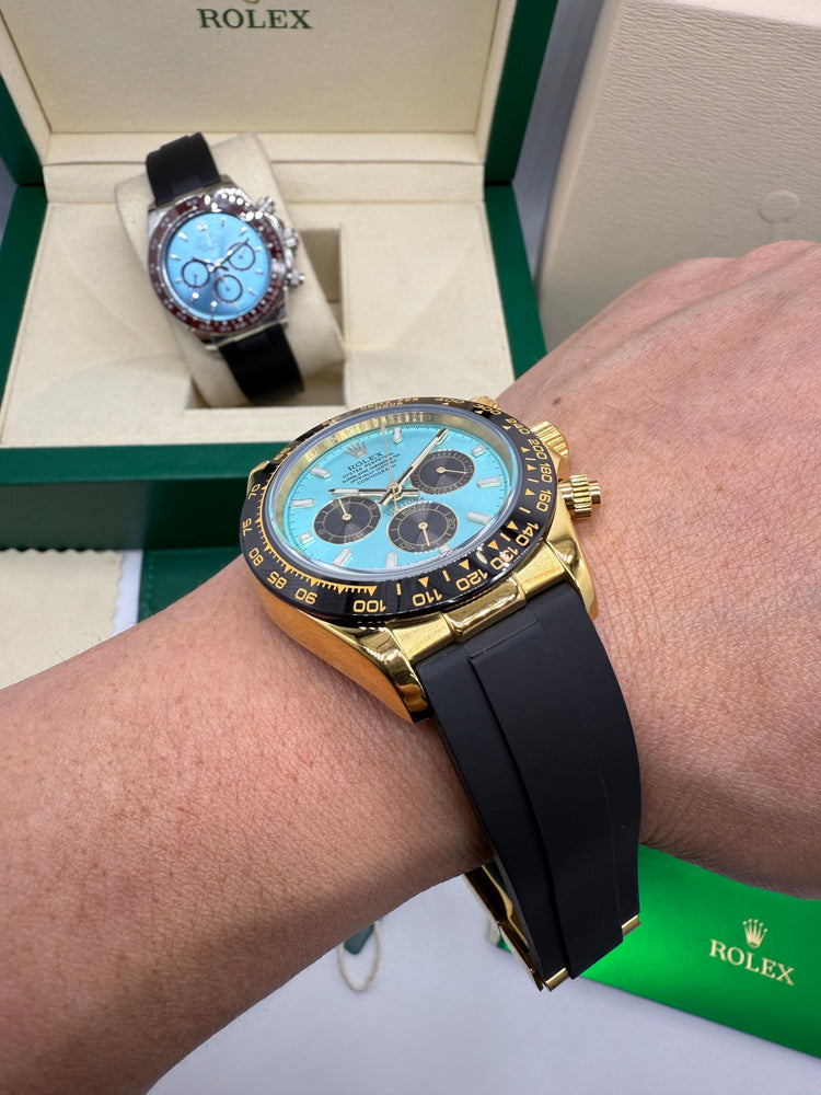 Relógio Rolex Daytona em ouro e pulseira azul, com cronógrafo e mostrador azul no pulso.