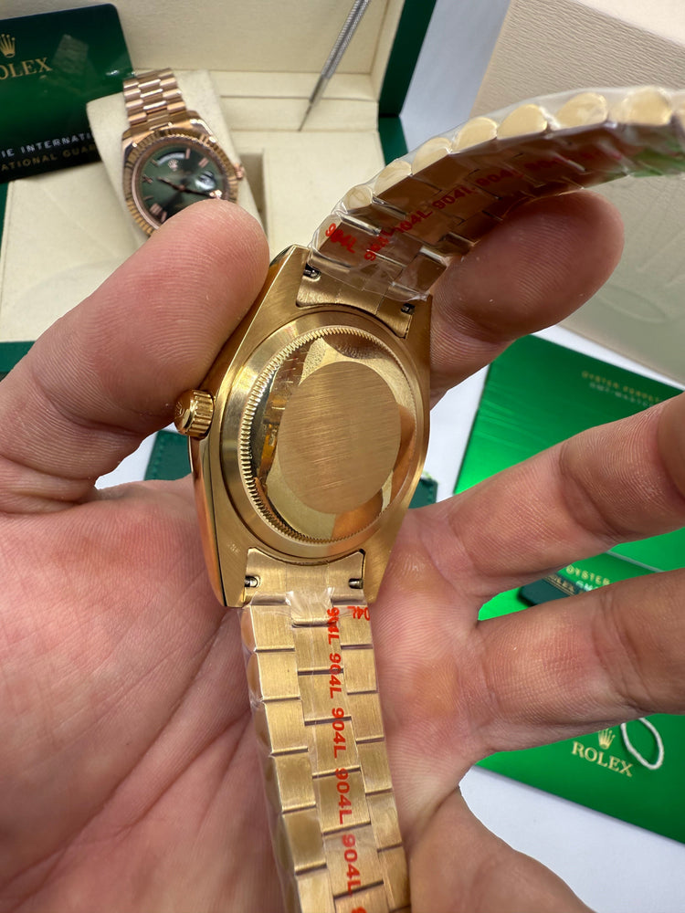 Relógio Rolex dourado com fundo traseiro e marcações na pulseira metálica.