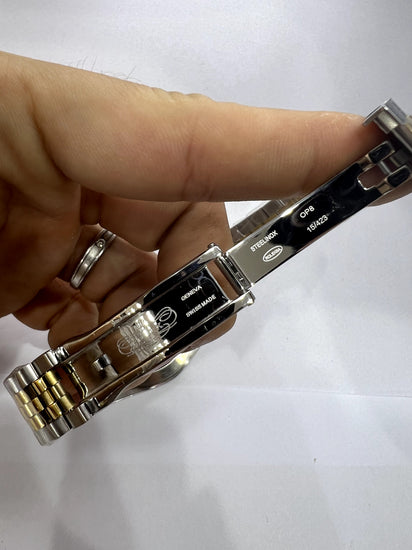 Relógio bicolor com pulseira metálica e fundo com marcações na lateral