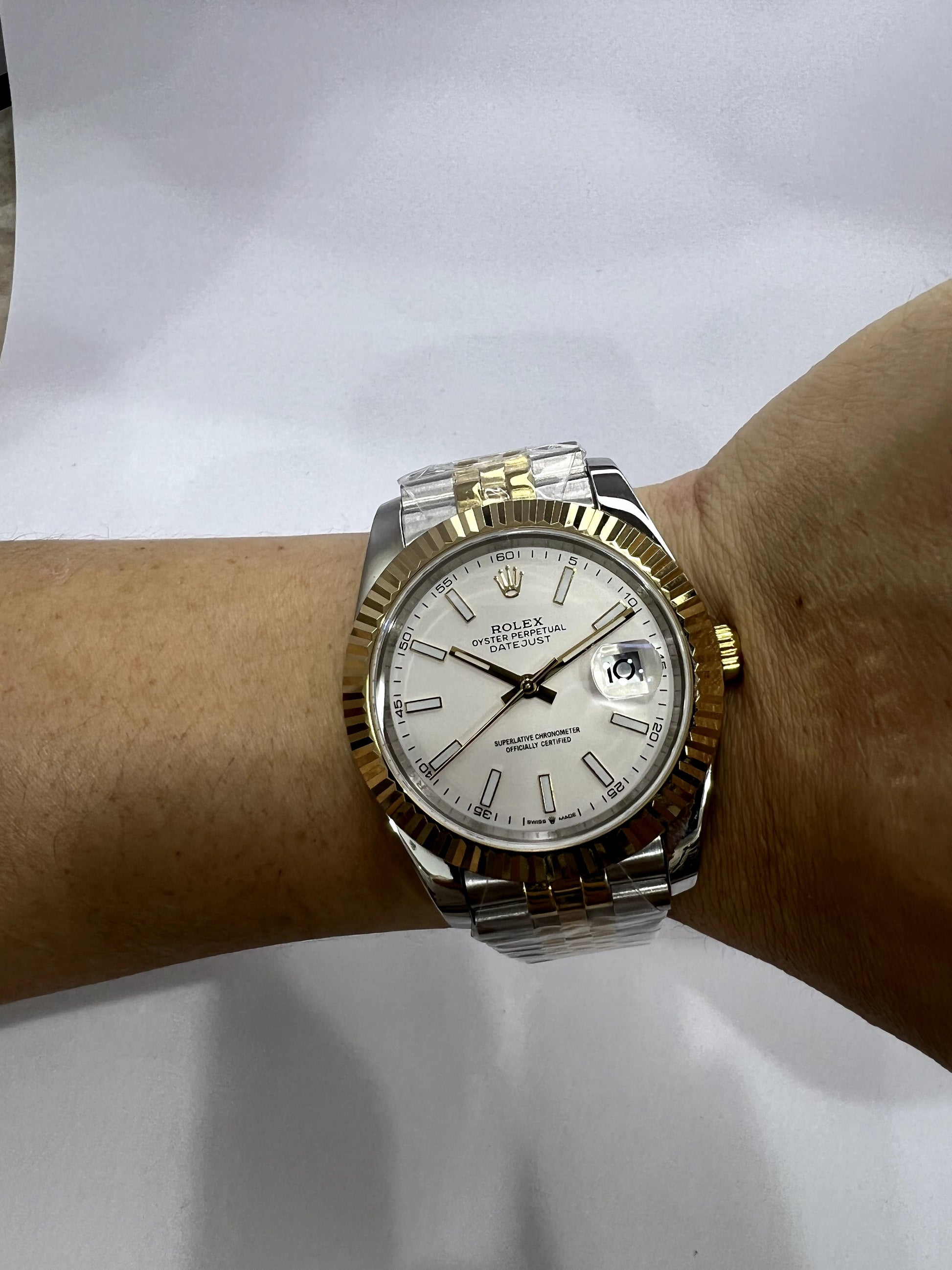 Relógio bicolor com mostrador branco, janela de data e pulseira de aço dourado