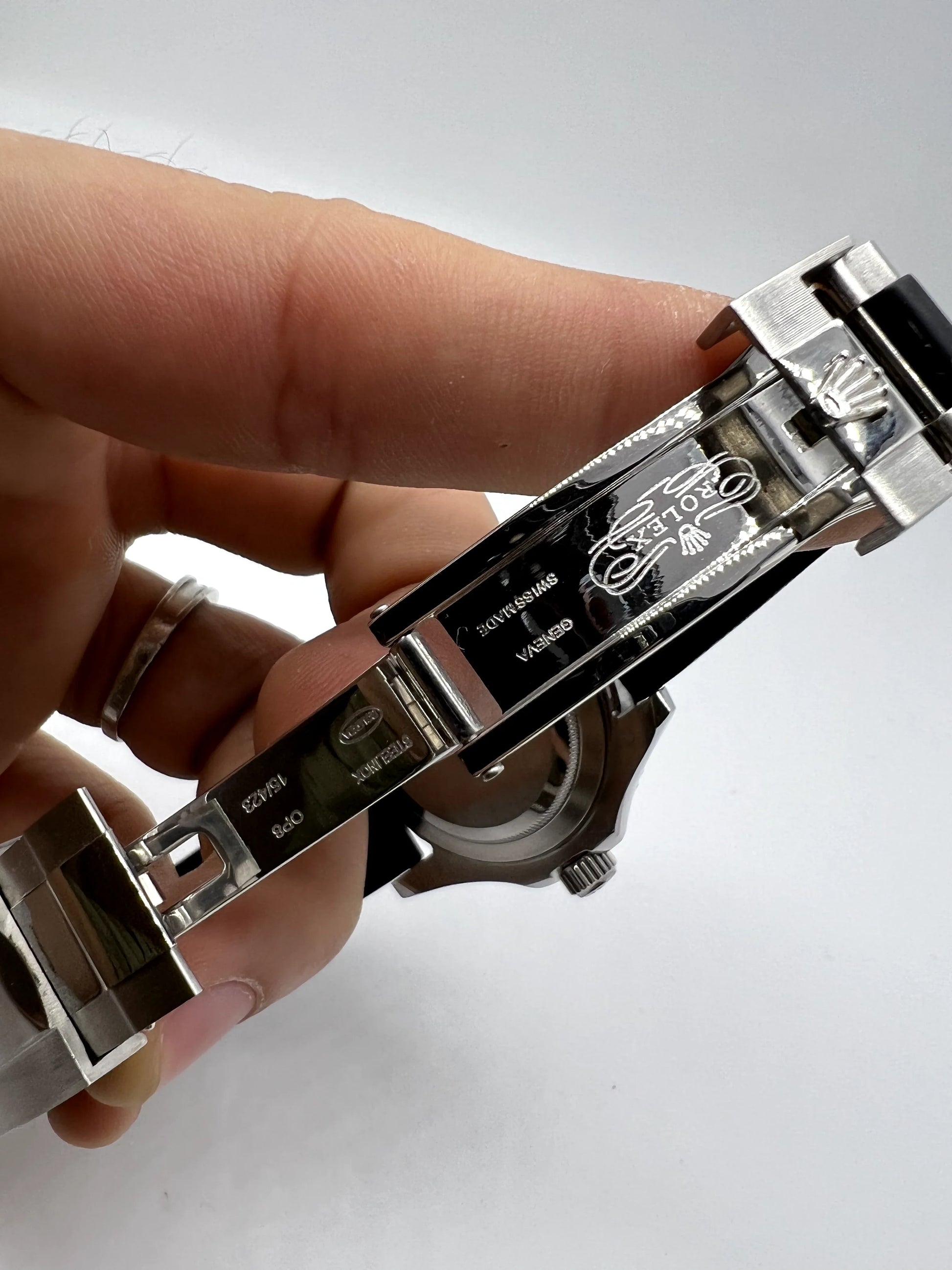 Fecho do relógio Rolex automático com partes metálicas e pulseira de borracha preta.