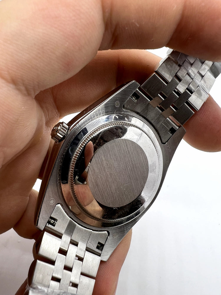 Relógio Rolex com fundo e coroa visíveis, pulseira de aço com elos