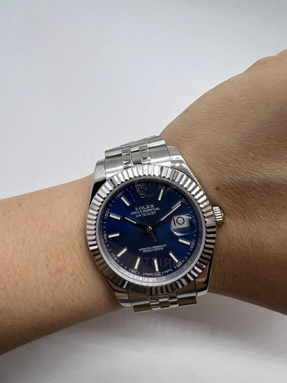 Relógio Rolex no pulso com mostrador azul, pulseira de aço e marcador de dia 10