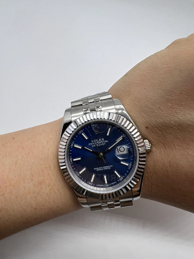 Relógio Rolex no pulso com mostrador azul, pulseira de aço e marcador de dia 10