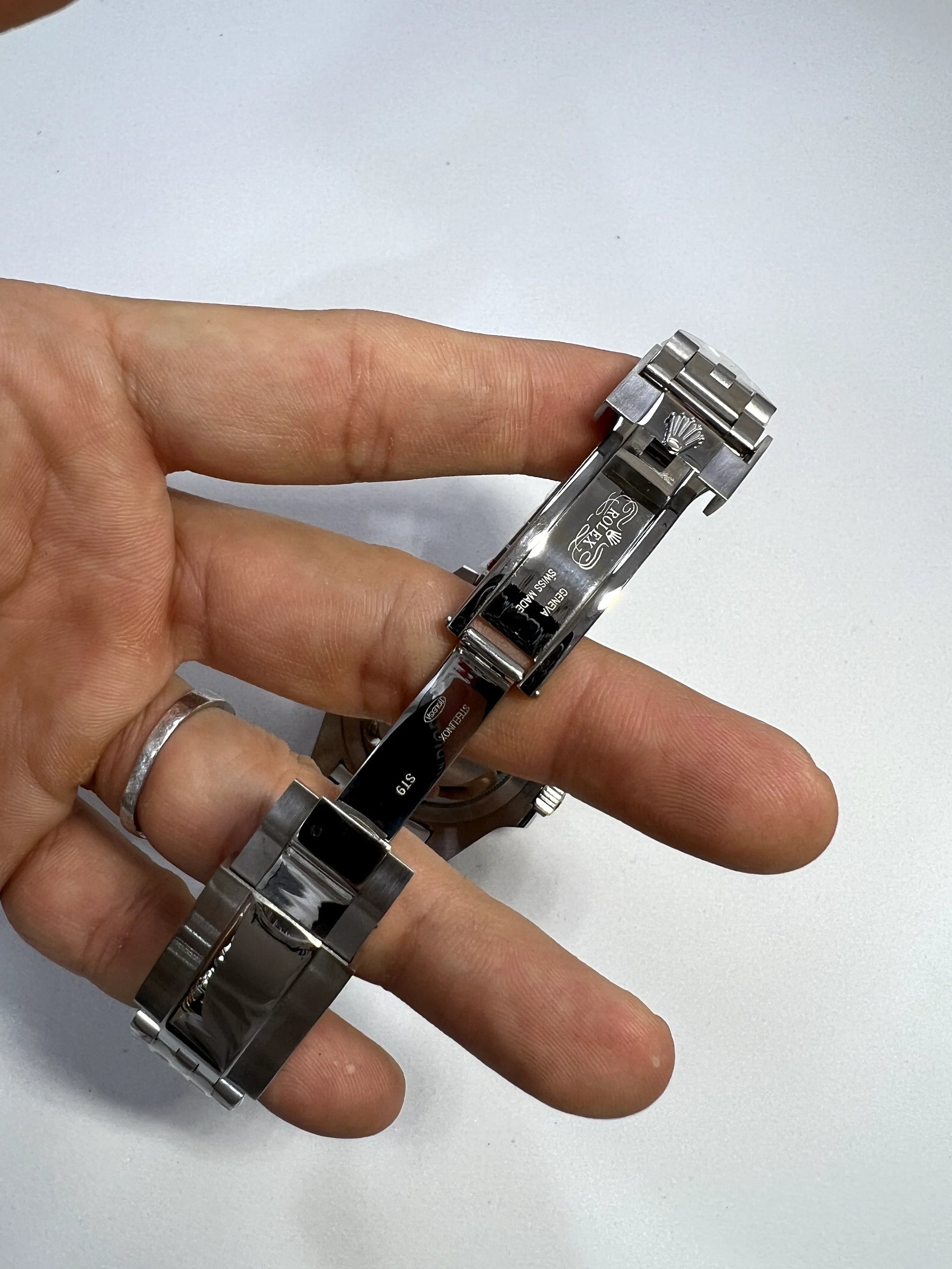 Fecho e pulseira de aço do relógio Rolex, vista com mãos