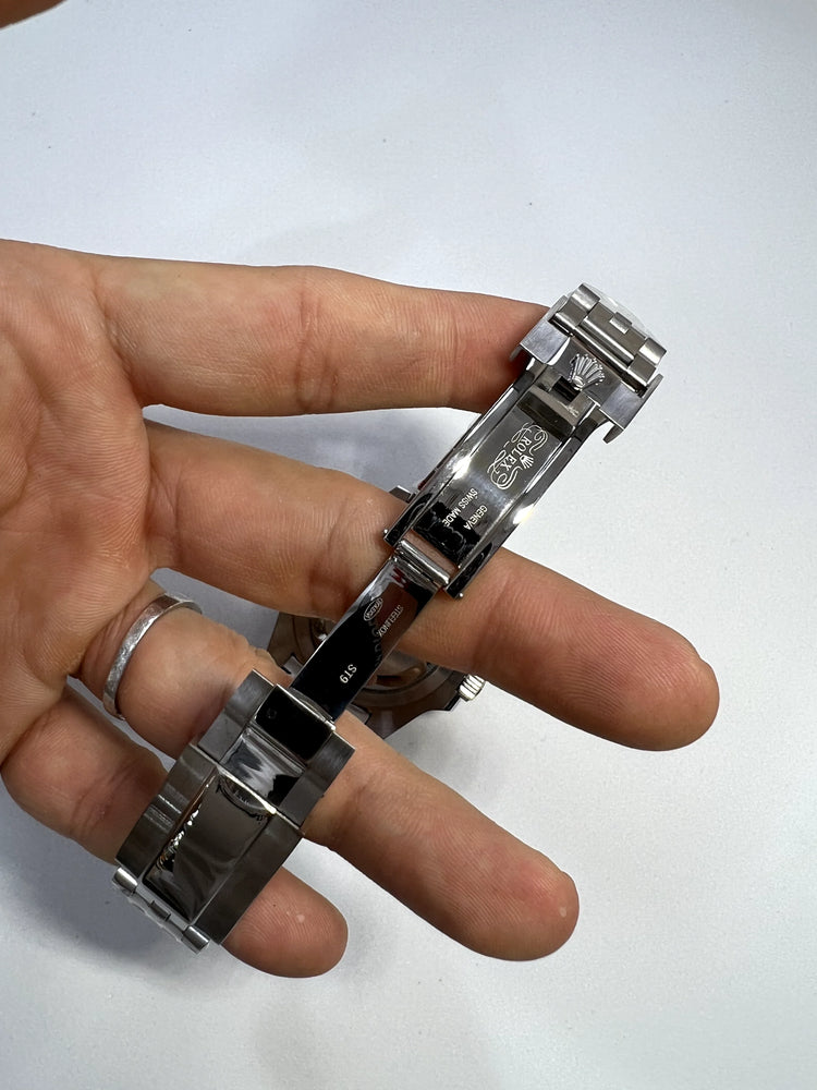 Fecho e pulseira de aço do relógio Rolex, vista com mãos