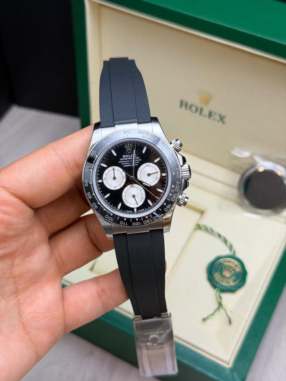 Relógio Daytona prateado com mostrador preto, cronógrafos e pulseira azul-marinho