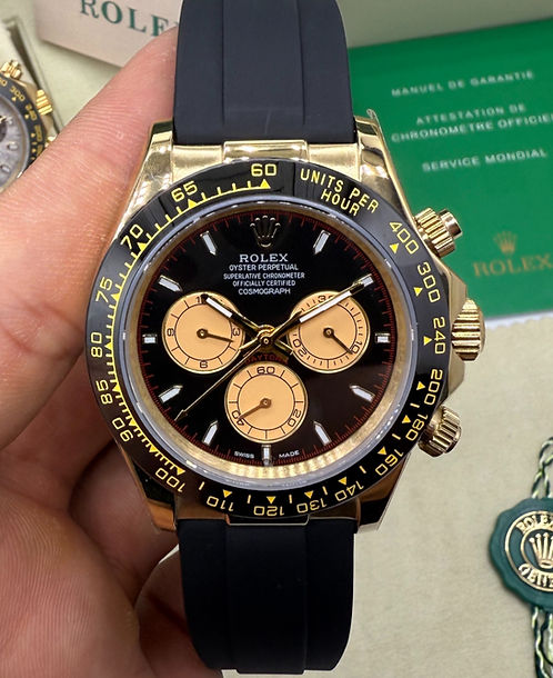 Relógio Daytona com mostrador escuro e totalizadores, pulseira de borracha azul e caixa dourada.