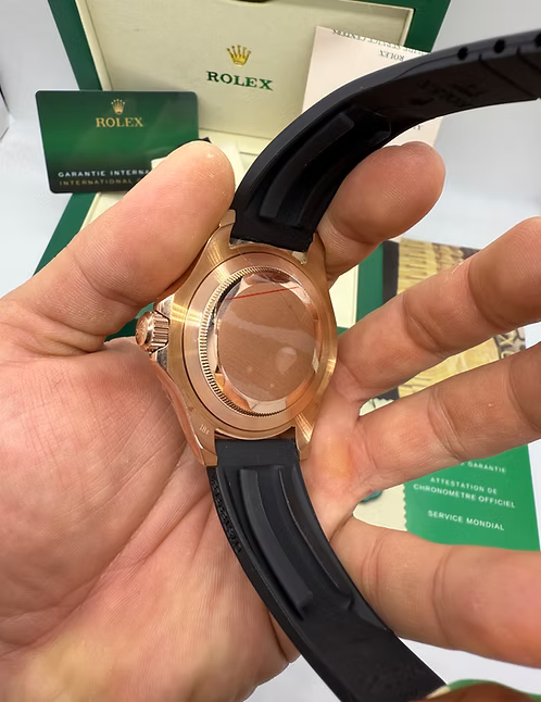 Relógio Rolex com caixa em ouro rosé e pulseira de borracha preta, visto de lado