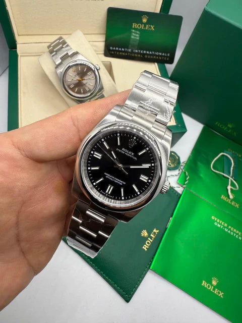 Relógio Rolex com pulseira de aço, mostrador preto e coroa lateral