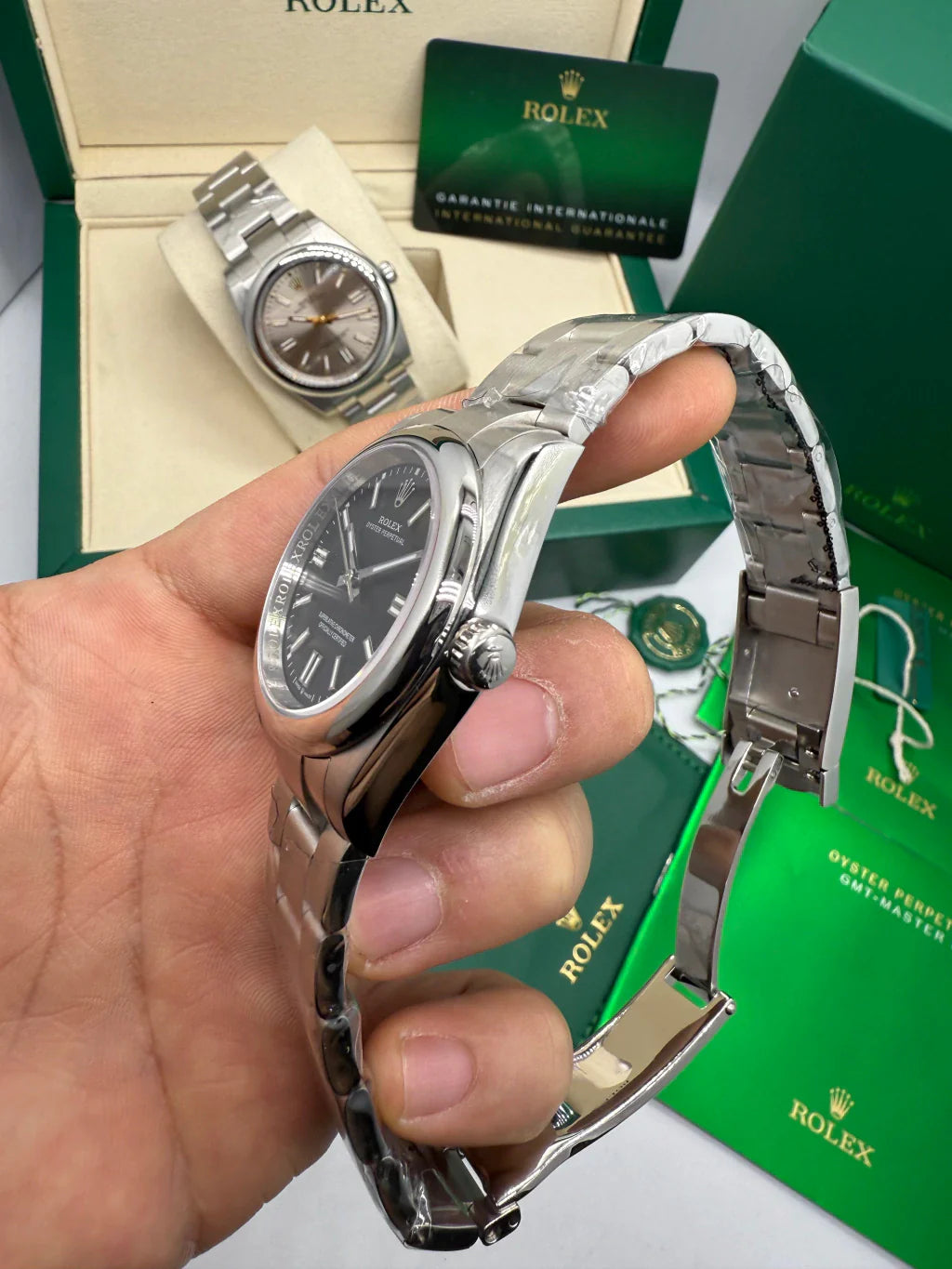 Relógio Rolex com caixa e pulseira de aço, vista lateral com coroa