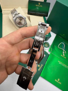 Relógio Rolex com pulseira de aço e mostrador amarelo, visão lateral