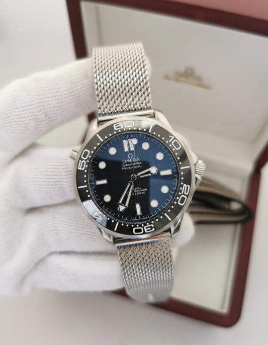 Relógio Omega com mostrador azul e bezel com marcações; pulseira de aço em malha