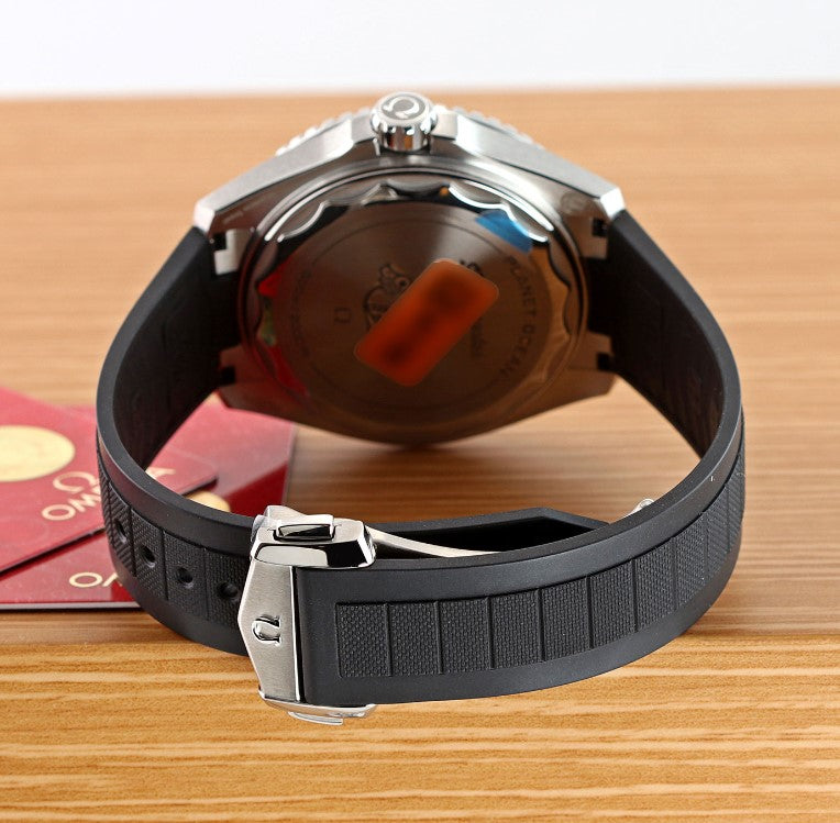 Relógio Omega com pulseira de borracha preta e fecho metálico, fundo do relógio visível