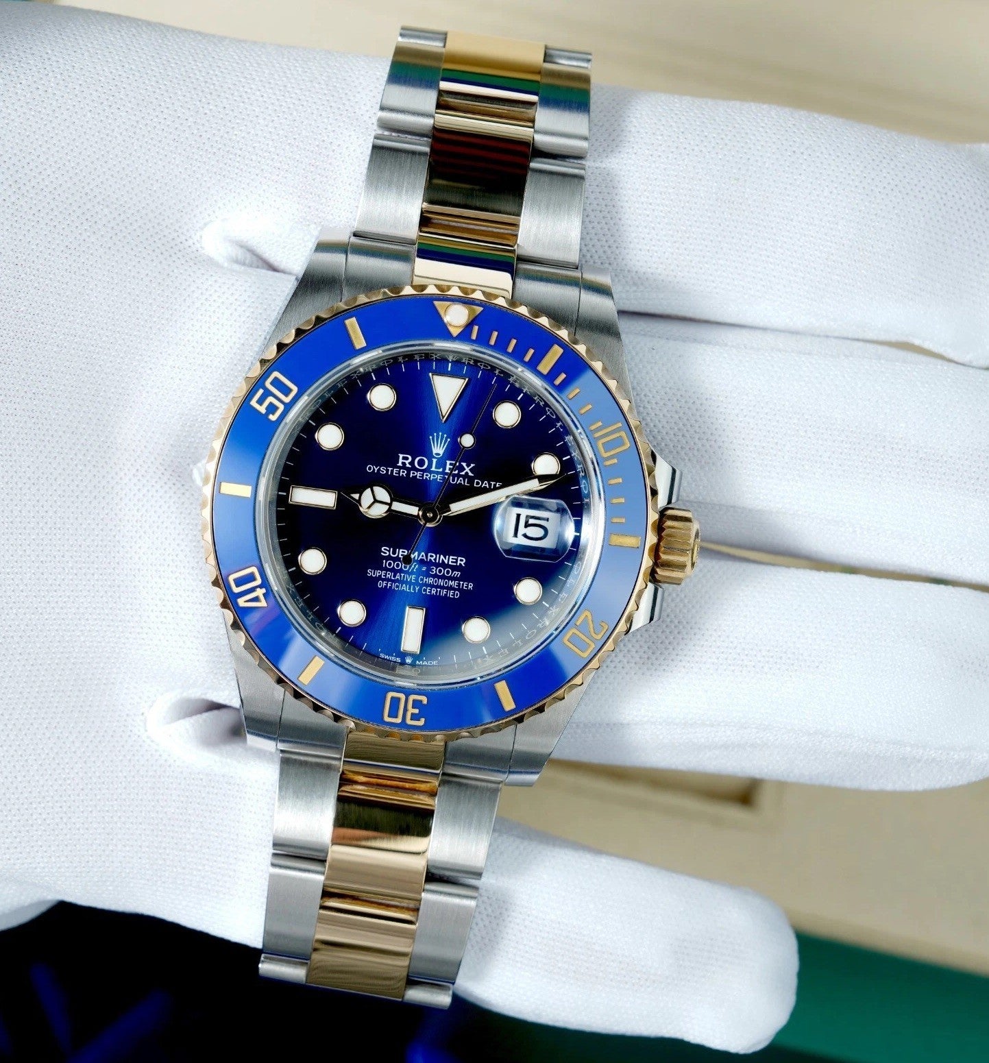 Relógio Rolex Submariner com pulseira bicolor e mostrador azul, marcadores e data.