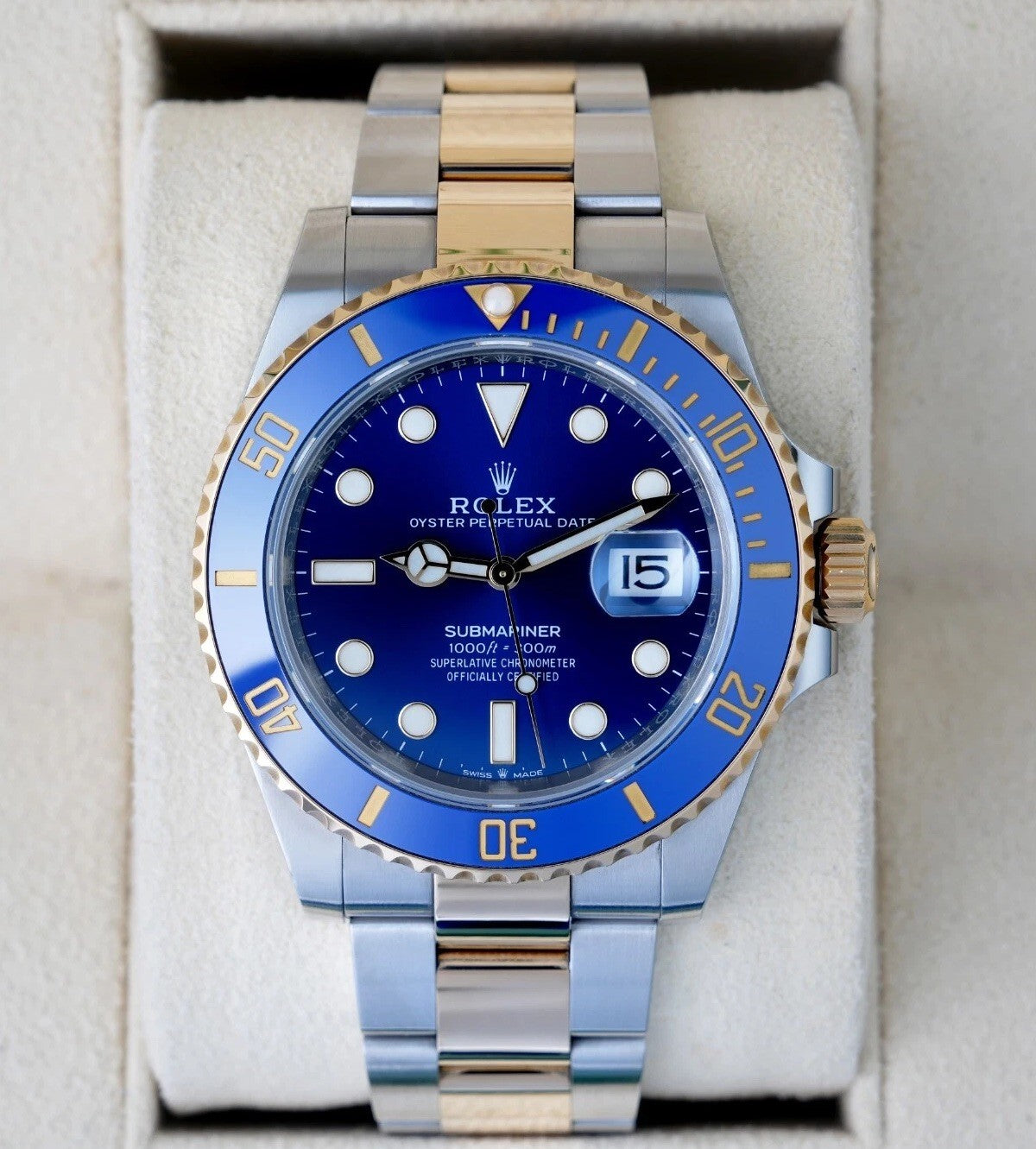 Relógio Rolex Submariner com mostrador azul e janela de data na pulseira bicolor.