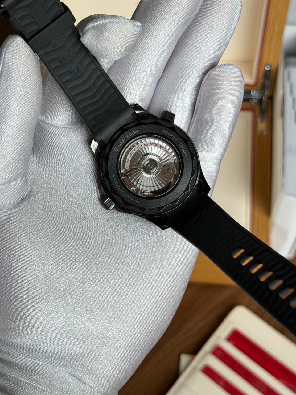Fundo do relógio com pulseira preta e caixa escura, visto na mão